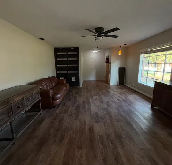 Living room looking toward front door and entry foyer, as viewed from doorway to kitchen. Furniture shown available for minor additional fee if agreed upon by tenant and owner.
