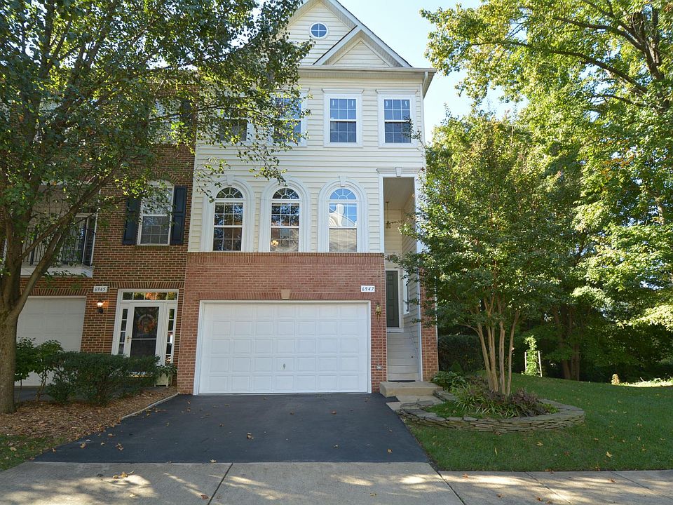 Front view of gorgeous, meticulously maintained end unit townhome on no-outlet street backing to wooded preserve.