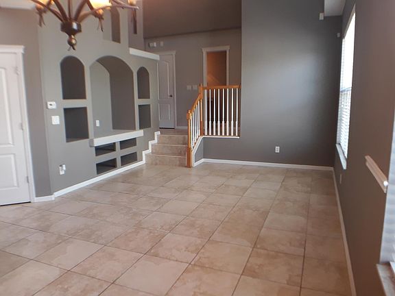 Large bright family room with built in displays and 2 story windows