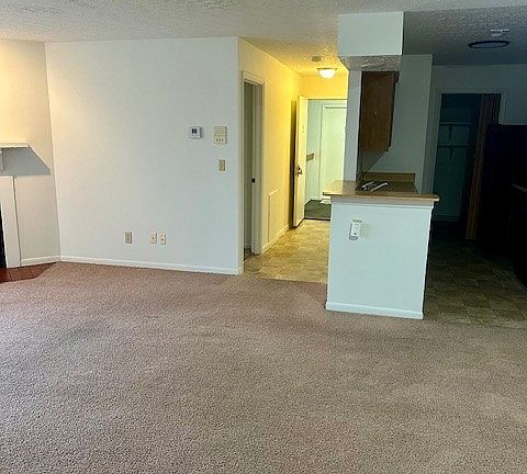 View of the entry hallway from the living room/dining room area. Kitchen on right- primary bedroom on left in hallway