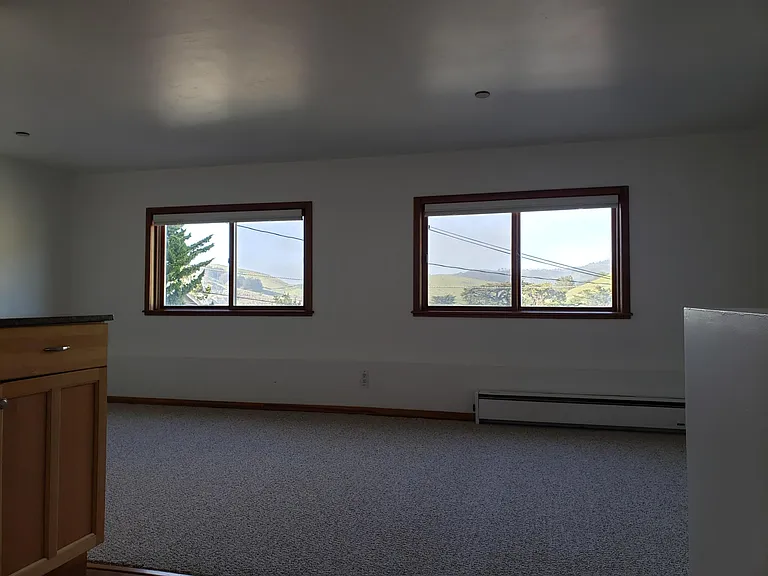 Living room and bedroom combo. Large, expansive windows with mountain views.