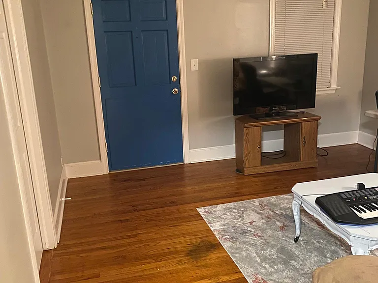 View of blue exterior front door from the living room. Gorgeous hardwood Mid Century floors!