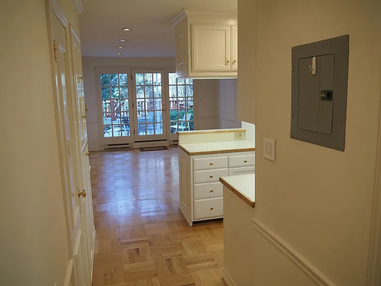 Hallway and living room. Kitchen off to right. Private patio beyond French doors.