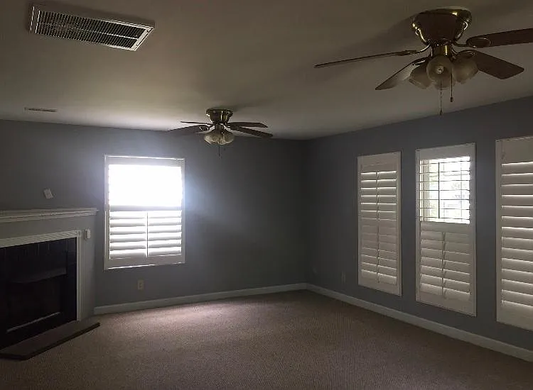 Large back bonus room with wall of windows and door to backyard and wall built-in doggie door. (note: the fireplace is electric)