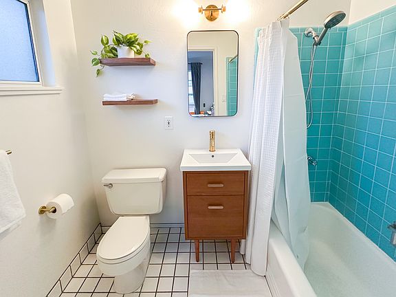 Chic vintage-modern bathroom with hotel luxury towels, hair dryer, and essentials.