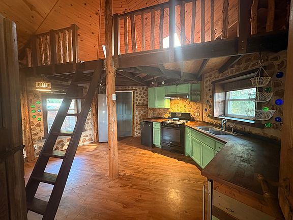 Kitchen with gas oven & stove, full size refrigerator, separat freezer and space for dining. Loft above is accessible by ladder shown.