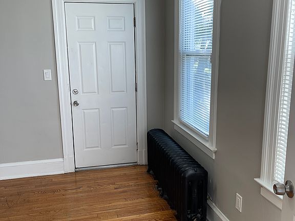 View of living room from the main entrance, looking at side balcony door