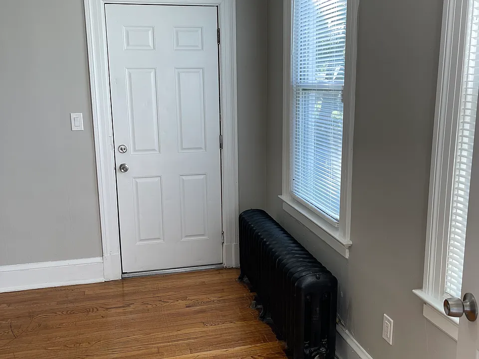 View of living room from the main entrance, looking at side balcony door