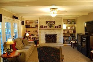 Den with fireplace, shelves, hard woods and french doors.