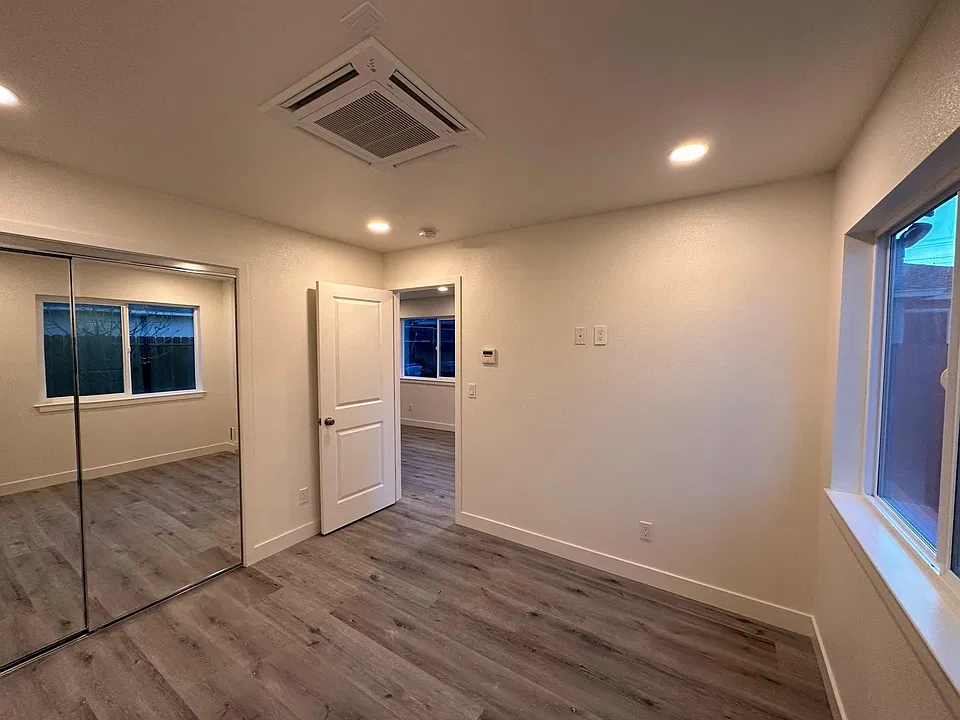 Bedroom with a window view into private (fenced) backyard with fruit trees