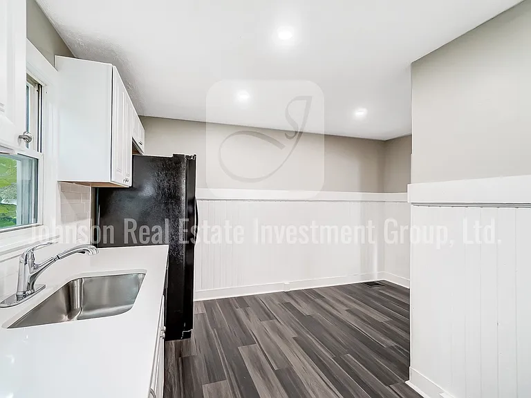 Stunning remodeled kitchen with black appliances and white quartz countertops!