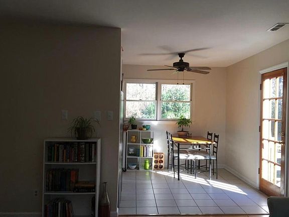 Dining area off the living space and kitchen, with oversized windows, and additional door to the outside.