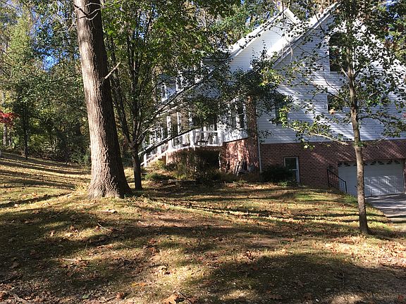 right side of home from driveway viewing two car garage entrance under home