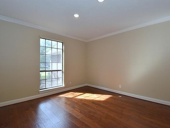 Dining room has beautiful engineered wood floors, recessed lighting, and crown moulding.