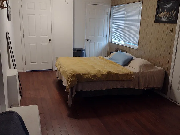Master bedroom bed and doors to walk in closet and newly renovated bathroom