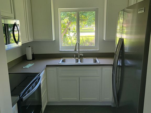 Partial View of Kitchen. New cabinets, refrigerator, oven, microwave, and dishwasher.