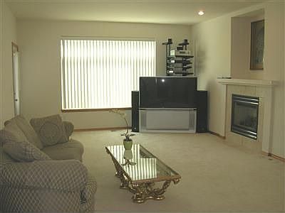 Family room off kitchen with cozy gas fireplace & door to backyard.