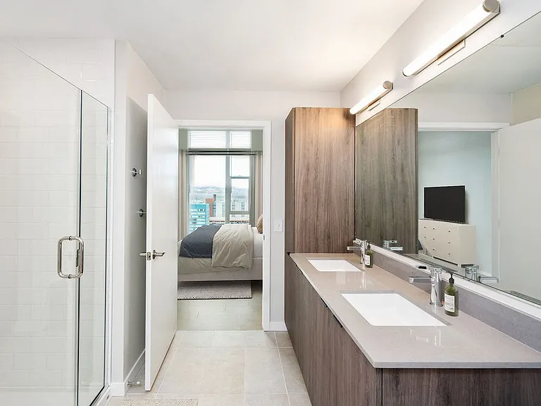 Signature Collection bath with marbled quartz countertop, double vanity, LED lighted vanity mirror, and tile flooring.