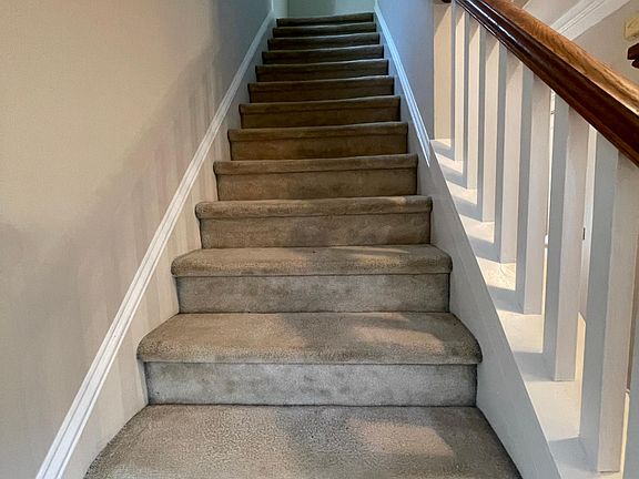 Carpeted stairs and large window.