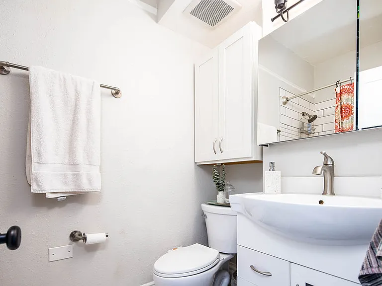 Remodeled bathroom with new bathtub, tile, and storage cabinets