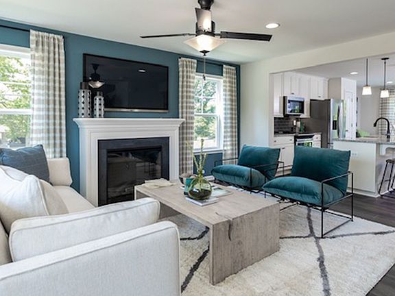 Living room with fireplace and large windows in a DRB Homes York II Garage Model.