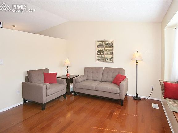 Living room with hardwood floors, window bench seat and vaulted ceilings.