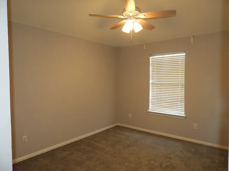 Bedroom 2 with ceiling fan and walk-in closet.