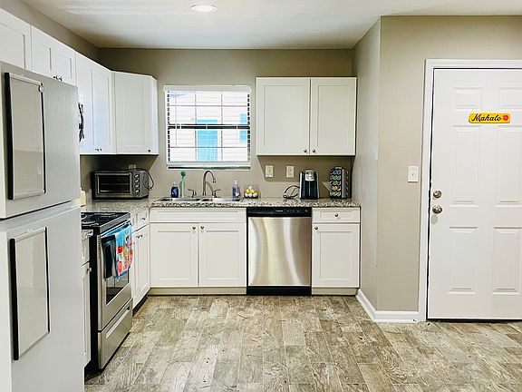 Fully furnished kitchen with plenty of cabinets for storage, granite countertops, stainless steel appliances, and more.