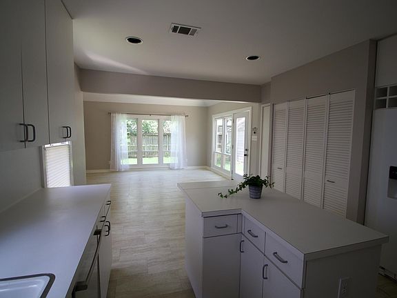 White kitchen open to family room which overlooks the yard.