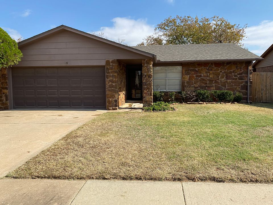Front view of property featuring a two car garage. The long covered entry allows for protection from the elements. The yard and landscaping are easy to maintain.