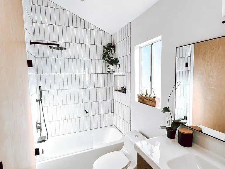 Newly renovated bathroom with rain showerhead and handheld sprayer