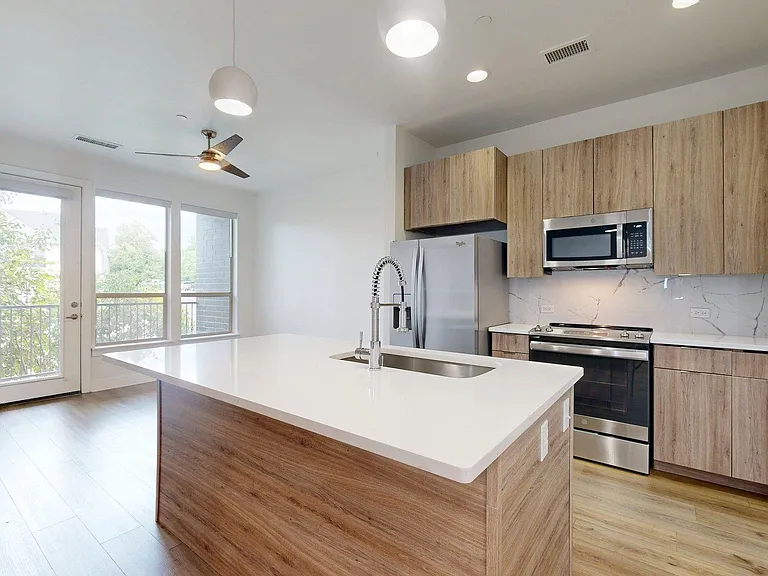 Apartment Kitchen with Stainless Steel Appliances, white countertops, pendant lights and wood-style flooring