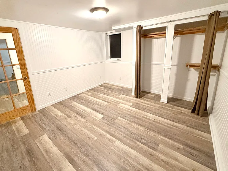 larger bedroom. 2 doors, 1 from kitchen hallway, 1 from smaller bedroom.
