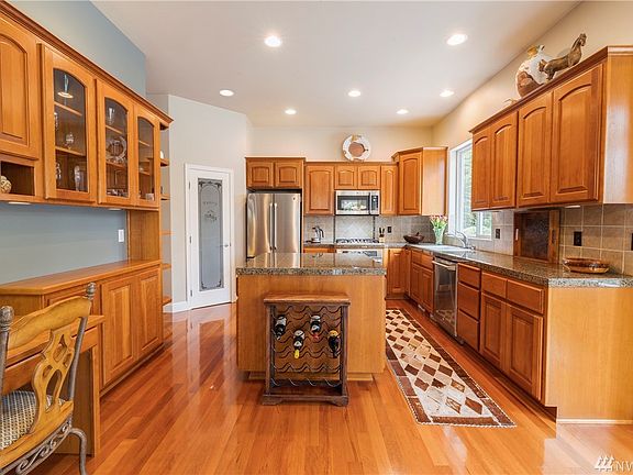 Another view of your kitchen with beautiful Brazilian cherry hardwood floors, granite counter tops, cherry cabinets and stainless steel appliances.