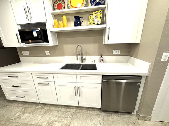 The kitchen has plenty of cabinet storage and appliances include a dishwasher, microwave, refrigerator disposal and more.
