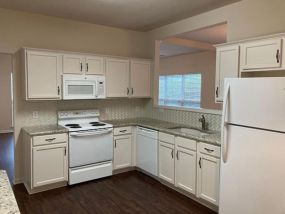 Kitchen (17_ x 11_1_) w/ granite countertops, tile backsplash, solid maple cabinets & double quartz sink. Entry to 2-car garage