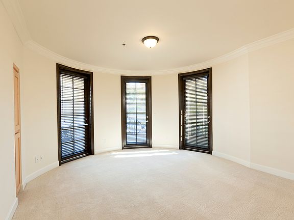 Primary bedroom with 1 round wall, three balcony doors.