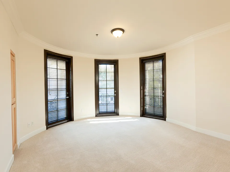 Primary bedroom with 1 round wall, three balcony doors.