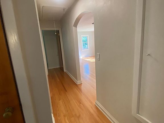 this hall connects the bedrooms and bathroom to the living/dining room. There's a coat closet (natural door to left) and a large linen closet (painted to the right)