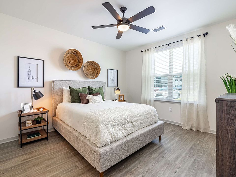 Cozy bedroom with ceiling fan and attached private bathroom at The Groves at Lake Juliana