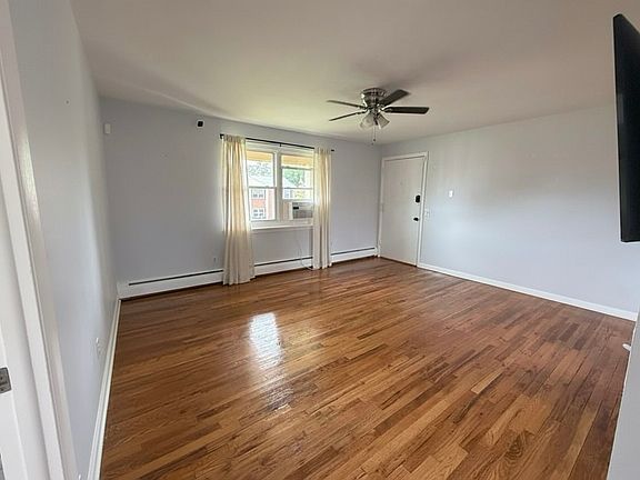 Living room with window facing backyard and exterior exit.