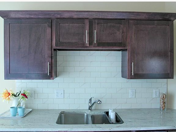 Custom stained cabinets with tiled backsplash