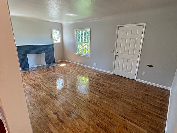 Living room: Access to street parking, kitchen and hallway leading to main level bath and bed. Also steps leading upstairs.