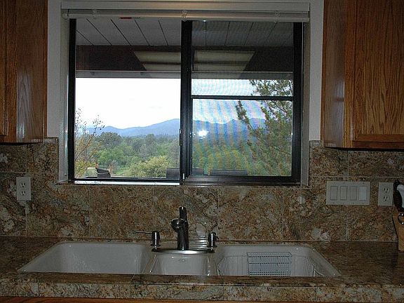 View through kitchen window of 18th and 1st fairways and western mountains.