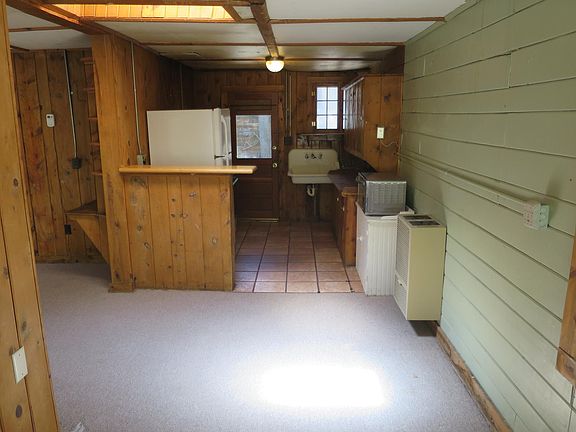 View of kitchen from dining area with skylight. Kitchen has propane cook stove and refrigerator.