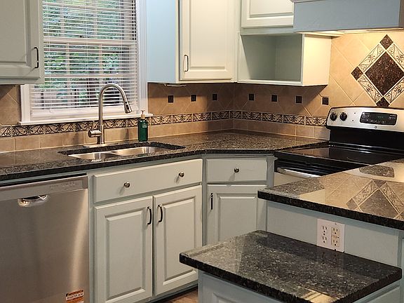 Kitchen with skylight and window overlooking backyard.