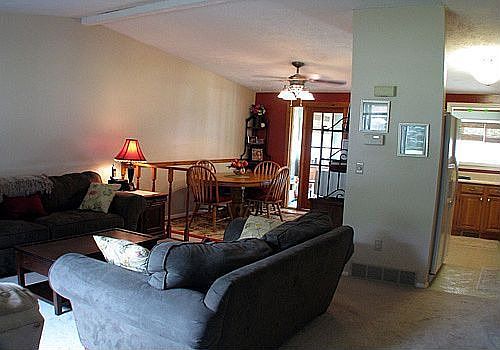 Main living room with open vaulted ceiling, french doors to sun room