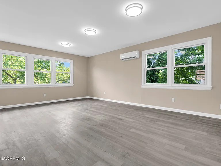 Bright open-concept living and dining space with mini-split AC and new flooring