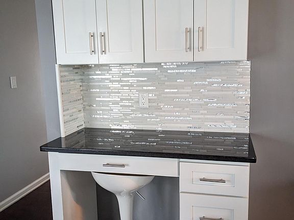 Built-in kitchen workstation with granite countertop, upper cabinetry and additional storage.