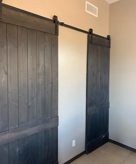 Barn doors in bedroom closing off the walk-in closet and bathroom.